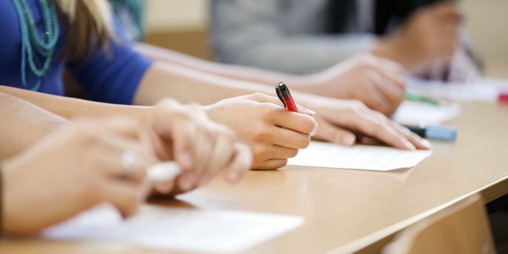 A girl holding pen and paper on the table