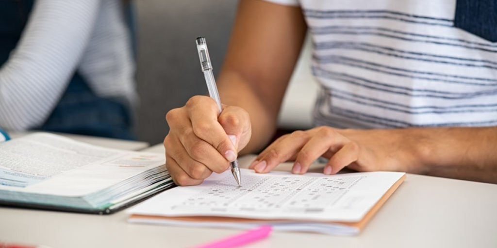 A boy marking the book with a pen.