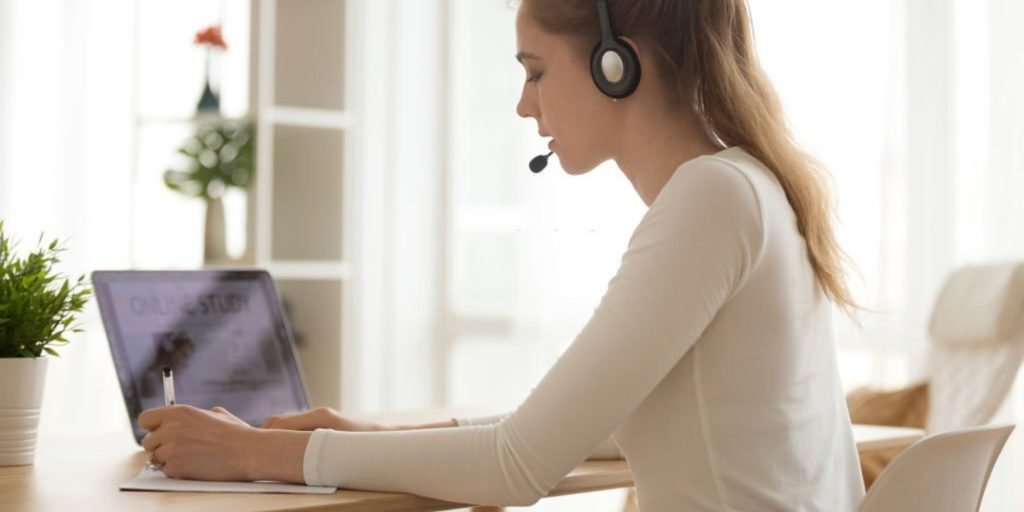 A girl is wearing headphones and solving the paper